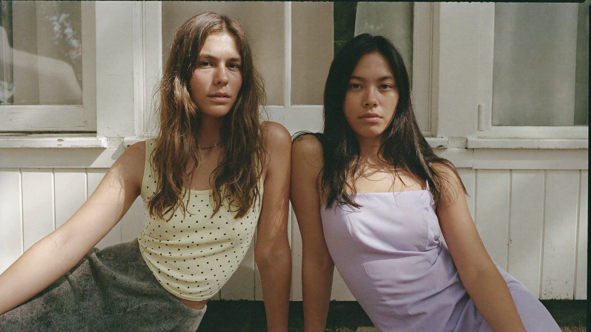 Lumina & Co. hero campaign image — two women reclining outdoors